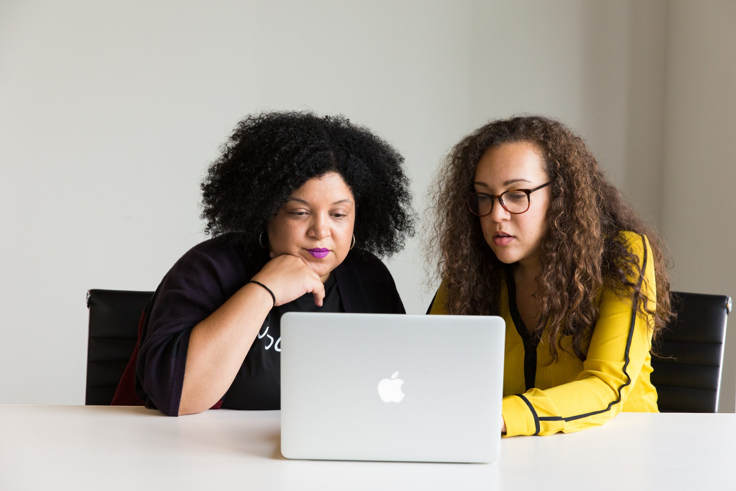 Two women talking about something on a computer screen