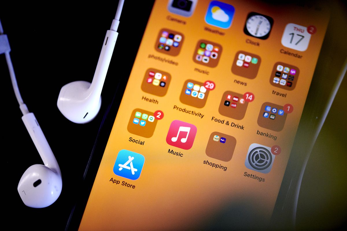 An Apple iPhone screen and a set of ear bud headphones.